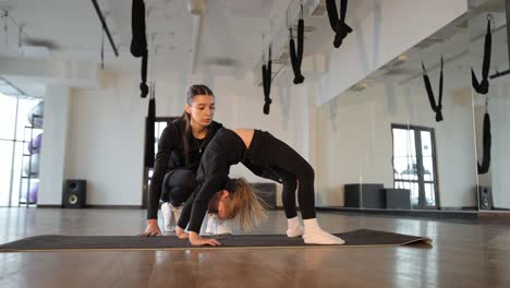 young girl doing backbend with instructor