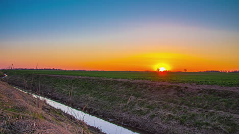 time-lapse of yellow sun at horizon rising in sky over cultivated fields