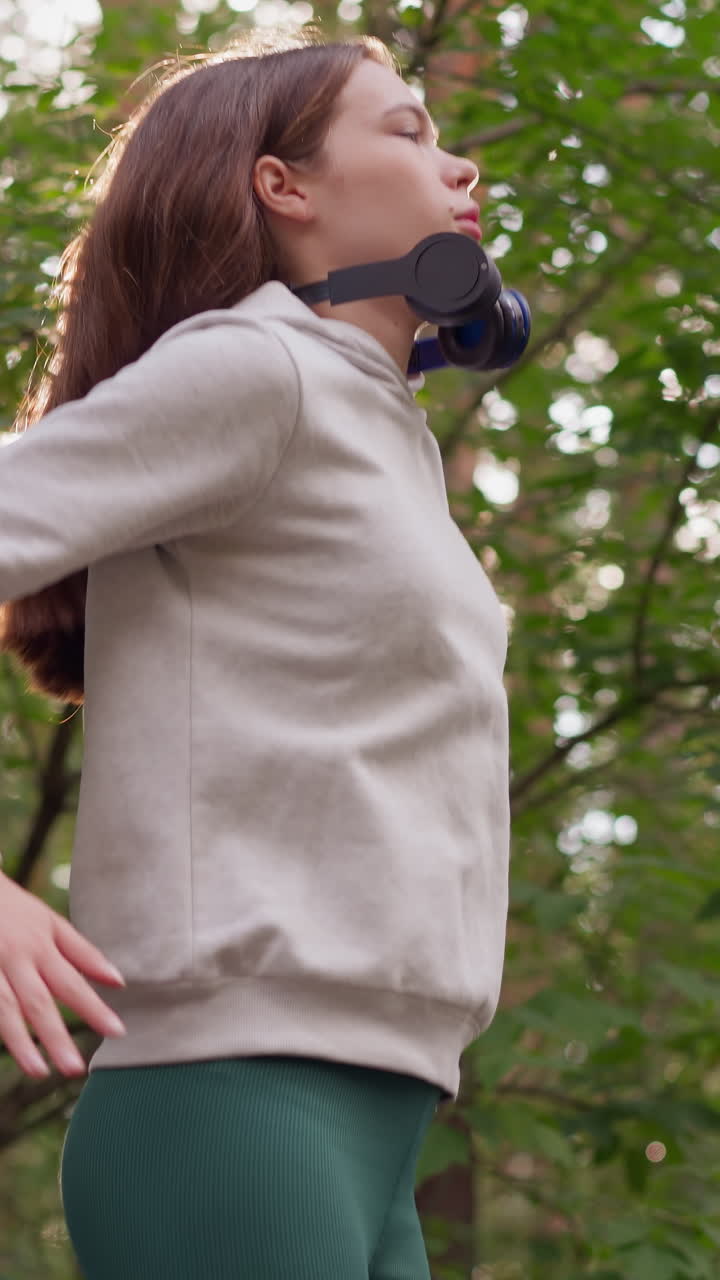 atleta mujer salta respirando profundamente en el bosque. preparación física para competiciones en la naturaleza en clima soleado. estilo de vida activo y obtener energía positiva del entrenamiento