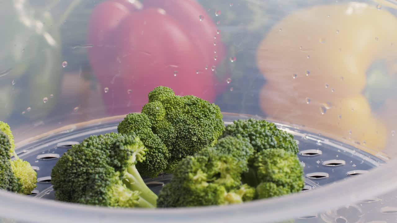 Mixed vegetables, carrots, broccoli, and cauliflower in a food double boiler steamer basket in a stainless steel pot, healthy diet cooking method preserving minerals, vitamins and flavor
