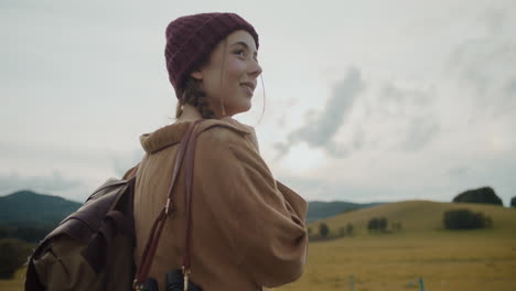 tourist with backpack exploring by meadow against sky