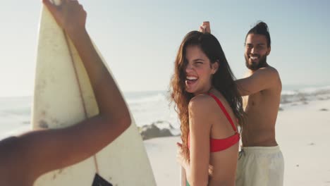 amigos sosteniendo sus tablas de surf detrás del mar