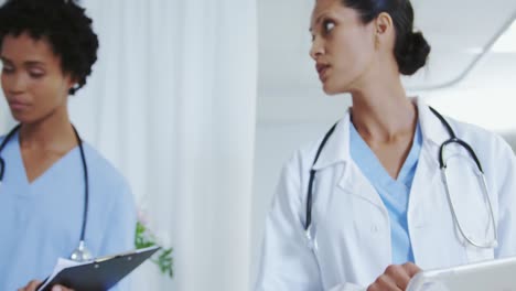 front view of african american female doctors attaching iv drip on male patient hand in the ward