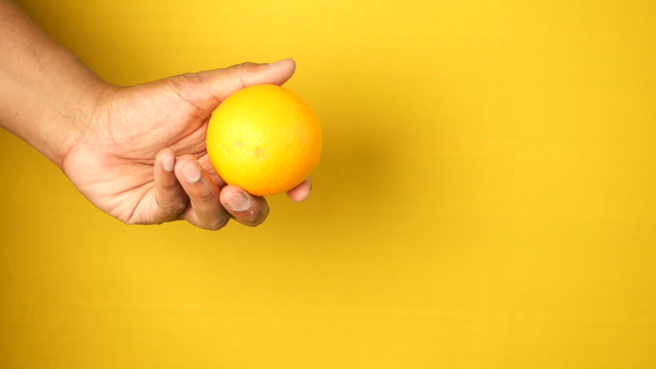 mano con una naranja