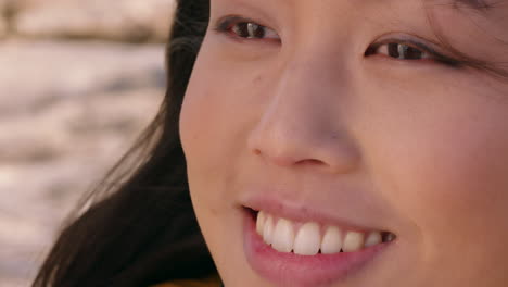 행복 한 아시아 여성 이 웃으며  ⁇ 은 날 을 즐기고 바람 이 불고 있는 머리카락 을 가지고 여름 휴가 에 휴식을 취하고 있는 모습