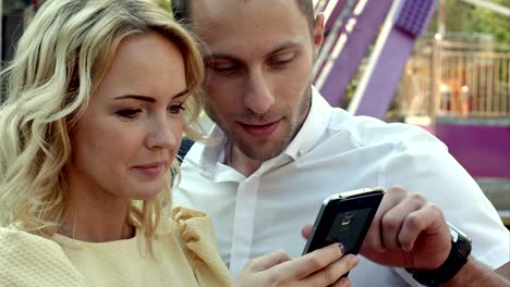 lovers laughing funny and having fun with a smart phone