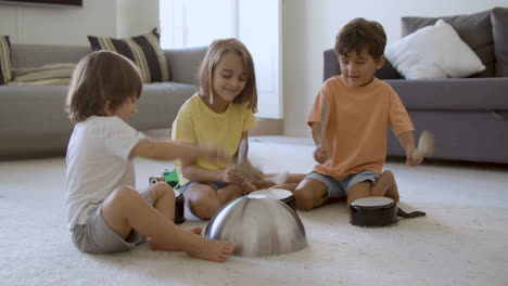 Happy-little-kids-playing-in-living-room-with-utensils