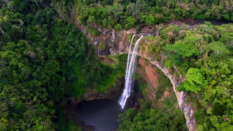 aerial view of a stunning waterfall in a lush tropical rainforest