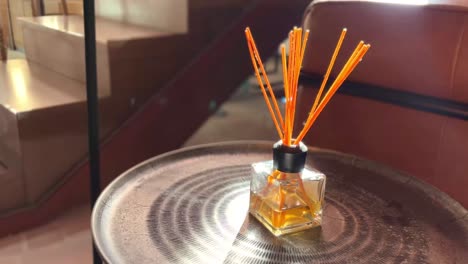 Orange-fragrance-sticks-on-a-small-living-room-table,-daily-home-care