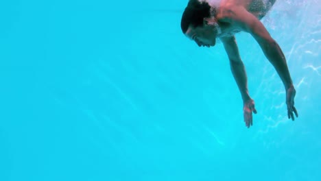 Hombre-En-Forma-Nadando-Bajo-El-Agua-En-La-Piscina