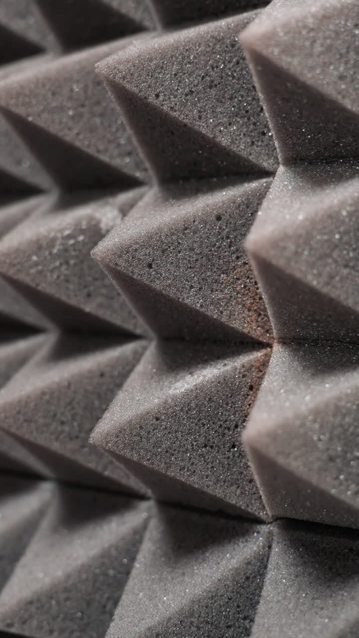 primer plano de paneles de espuma acústica con forma de pirámide, diseñados para absorber ondas sonoras, reducir el eco y controlar las reflexiones sonoras en un entorno de estudio