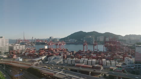 Aerial-rising-establishing-shot-over-Hong-Kong-industrial-port-facing-Tsing-Yi-on-clear-sunny-day