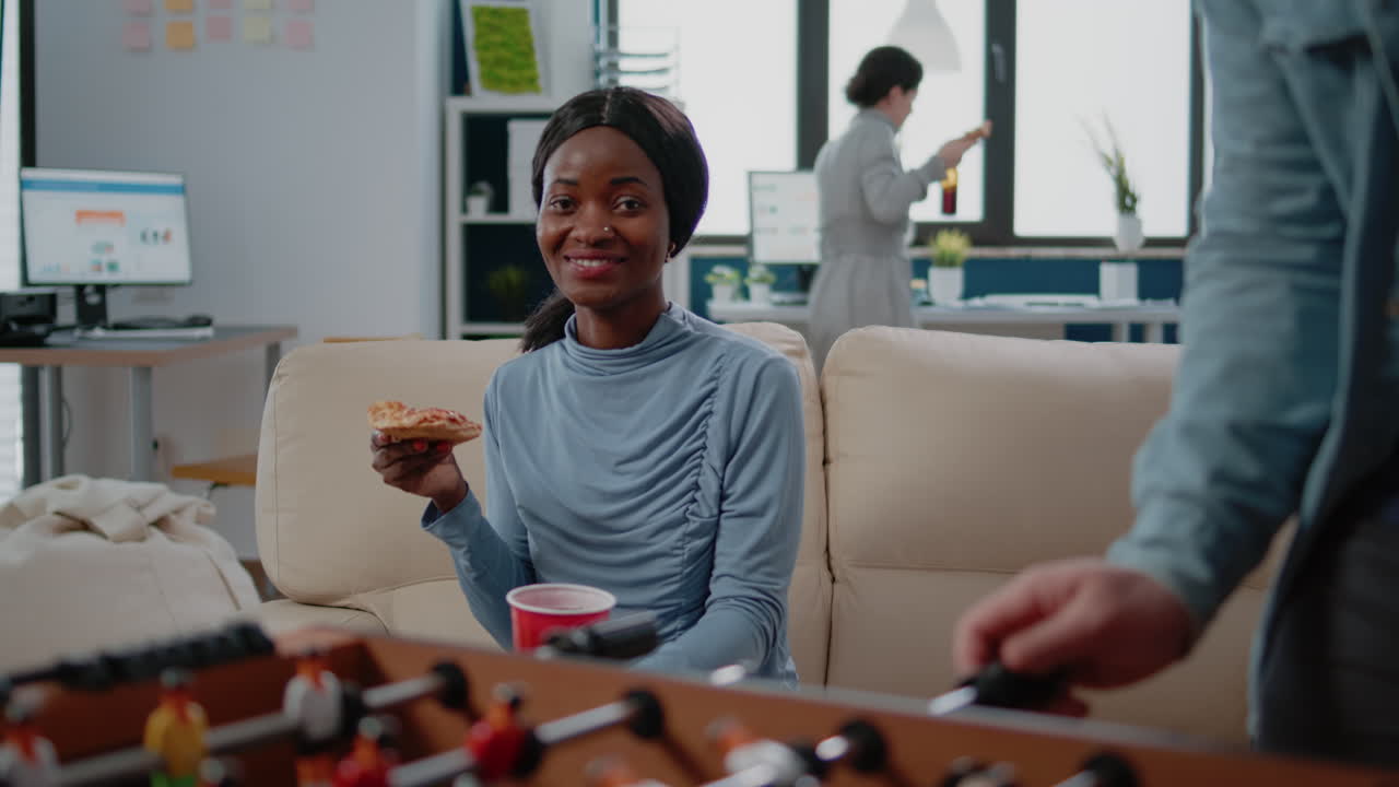 Portrait of woman holding slice of pizza and cup with beer