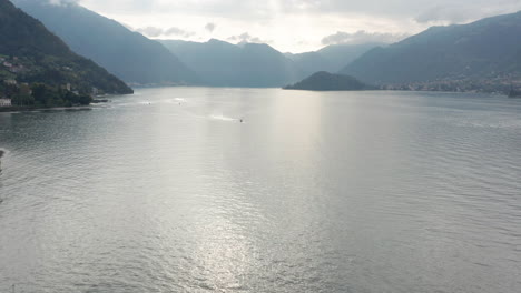 Drone-flying-towards-distant-boat-on-a-vast-and-beautiful-lake