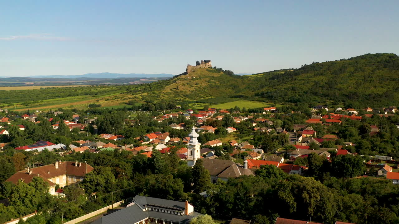 헝가리의 볼독쇠 성과 그 아래 마을의 넓은 회전 드론 샷