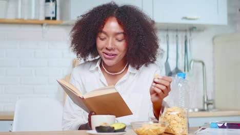 cheerful hispanic woman reads and laughs sincerely during leisure time