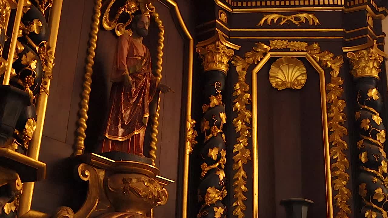 Vue détaillée d’une statue religieuse dorée placée dans une niche d’autel baroque ornée de la cathédrale