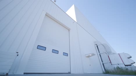 facade (front view) of a large hangar lined with a metal profile.