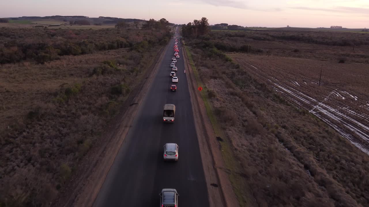 Atasco de tráfico en ruta rural al atardecer en Uruguay.