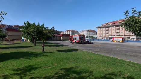 los bomberos con sus camiones en el patio de la escuela dan explicaciones en una charla a los estudiantes y maestros en el jardín de la escuela en un día soleado de verano, disparando un giro lento a la derecha