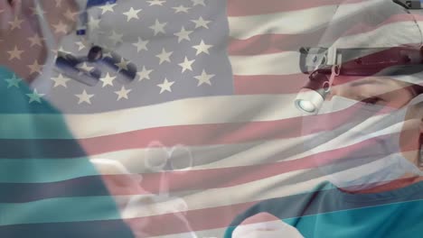 animation of flag of united states of america waving over surgeons in operating theatre