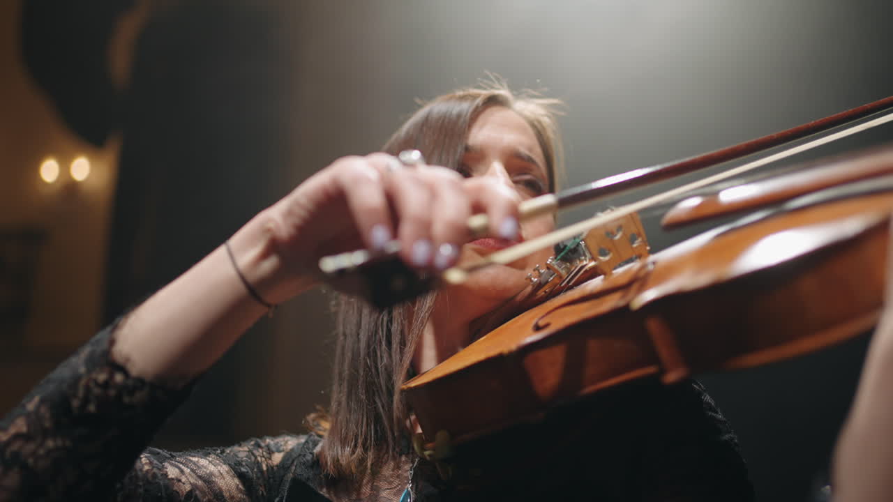 una joven talentosa está tocando el violín en la sala filarmónica retrato en primer plano de una música