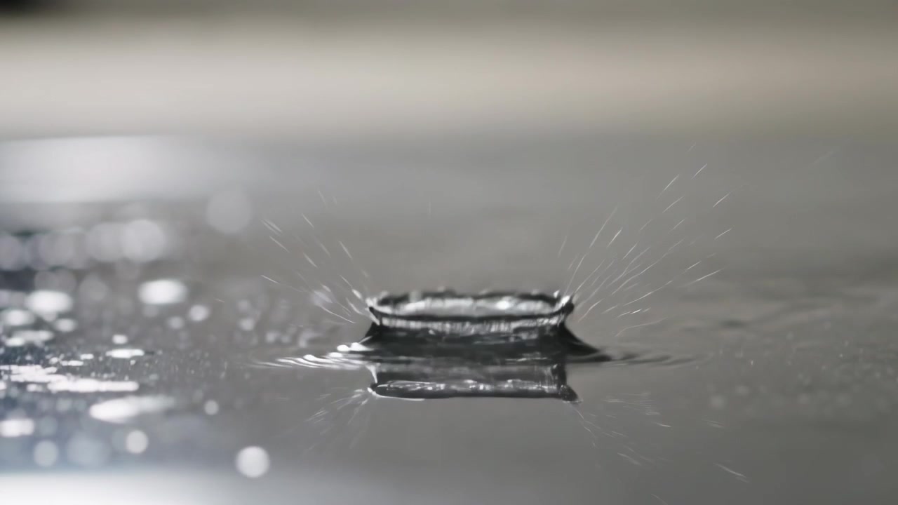 Forming bead on lip releasing droplet under gravity in lab onto mirror pool, producing crown splash