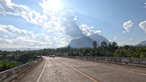 cars driving over a bridge on a sunny day