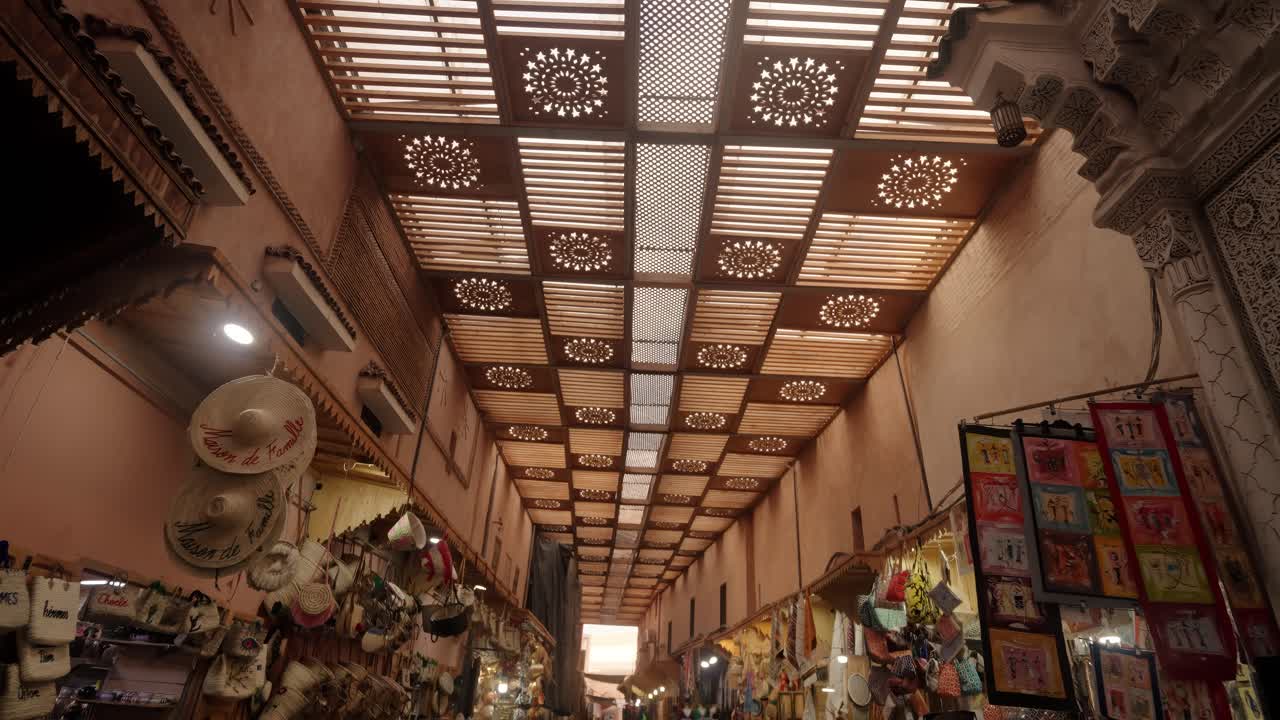 A wooden lattice roof with patterned light and a hanging lantern inside a Moroccan market