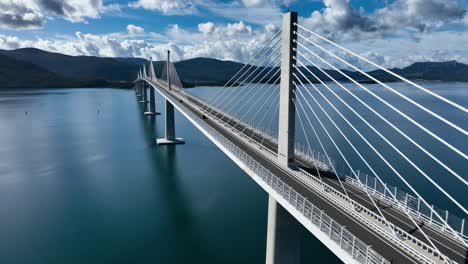 traffic on peljesac bridge across neretva channel in dubrovnik-neretva county, croatia. aerial orbiting shot