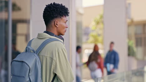 a student with books and headphones on campus