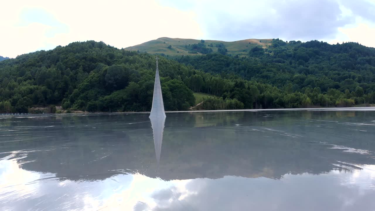 루마니아 룹사(lupsa)에 있는 게아마나(geamana) 마을의 독성 호수에서 교회 첨탑과 클라우드스케이프 반사