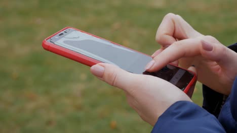 broken red phone screen. close up of woman's hand touching red mobile phone with blurred yellow green background, by sending sms messages.