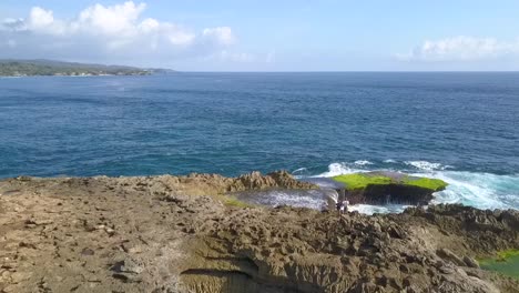 perfect aerial view flight fly forwards drone shot
big ocean waves crashing on the rocks of devil's tear at indonesia