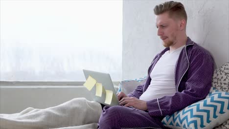 man working from home in pajamas
