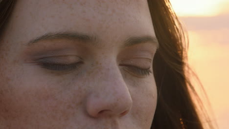 retrato de cerca hermosa mujer de cabeza roja abriendo los ojos meditando al atardecer orando explorando el estilo de vida espiritual disfrutando de la atención plena