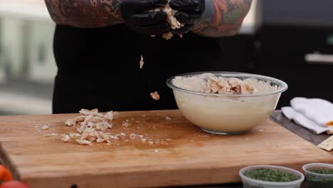 Man-mixing-chopped-smoked-fish-into-cheese-mix-and-spices