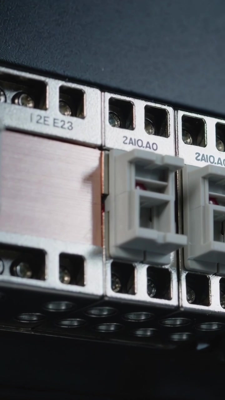Vertical video: Tilting camera revealing terminals inside cabinet with busbar and gray connectors