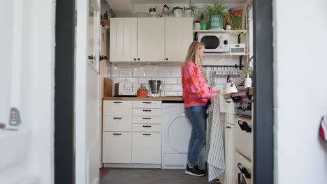 a woman in a bright, compact kitchen