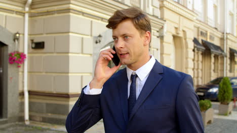 serious business man talking on mobile phone outdoors