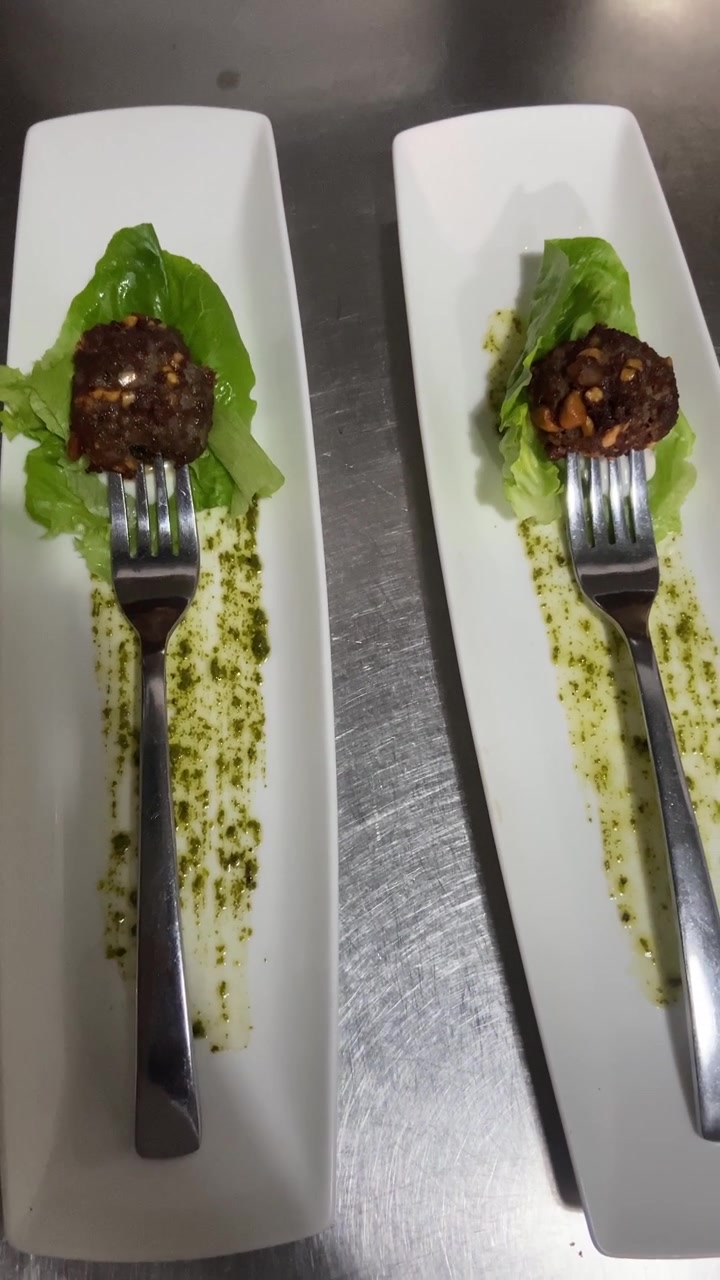 Gourmet Appetizer Bites Served on Lettuce Leaves with Pesto Sauce