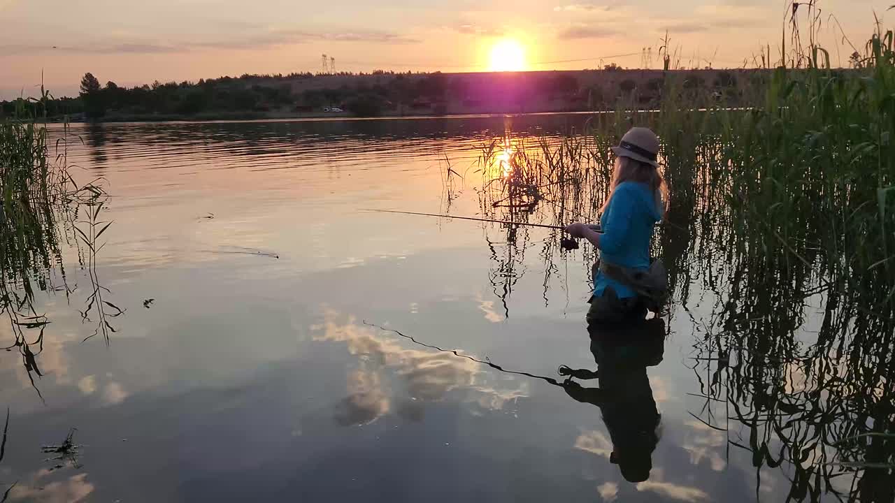hermosa chica pescando en un lago tranquilo durante la tarde