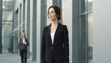 smiling businesswoman in the street and looking to the camera with crossed arms