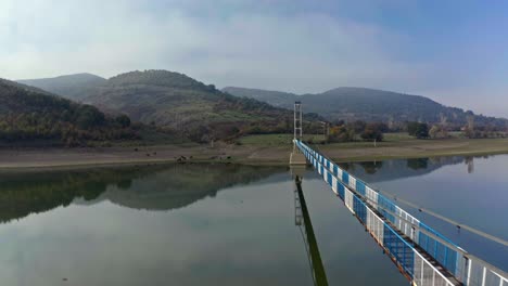 Aerial-flight-along-pedestrian-Suspension-bridge-above-Studen-Kladenets-Reservoir-in-Rhodope-Mountains-of-Bulgaria