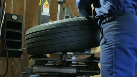 change a tyre, car mechanic is changing a tyre in a garage