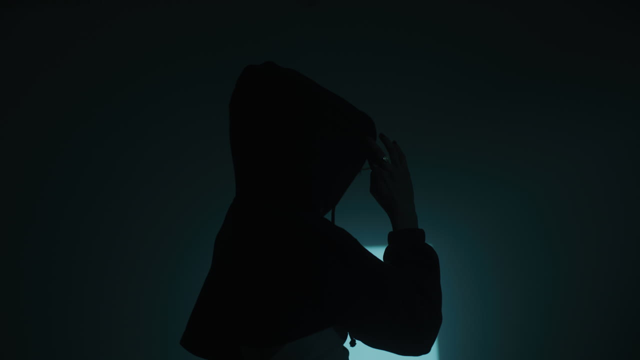 Woman in Hoodie in Dark Room