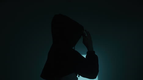 woman in hoodie in dark room