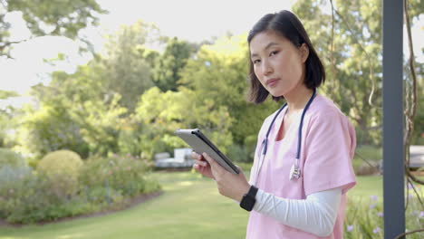 nurse in garden holding tablet and wearing stethoscope, providing home care, copy space