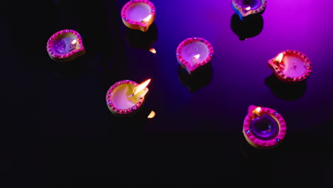 primer plano de las velas coloridas que queman celebrando diwali sobre un fondo negro