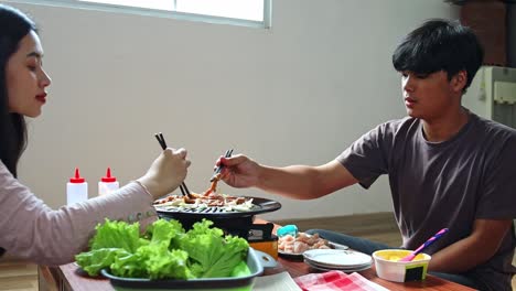 couple enjoying an indoor bbq meal together